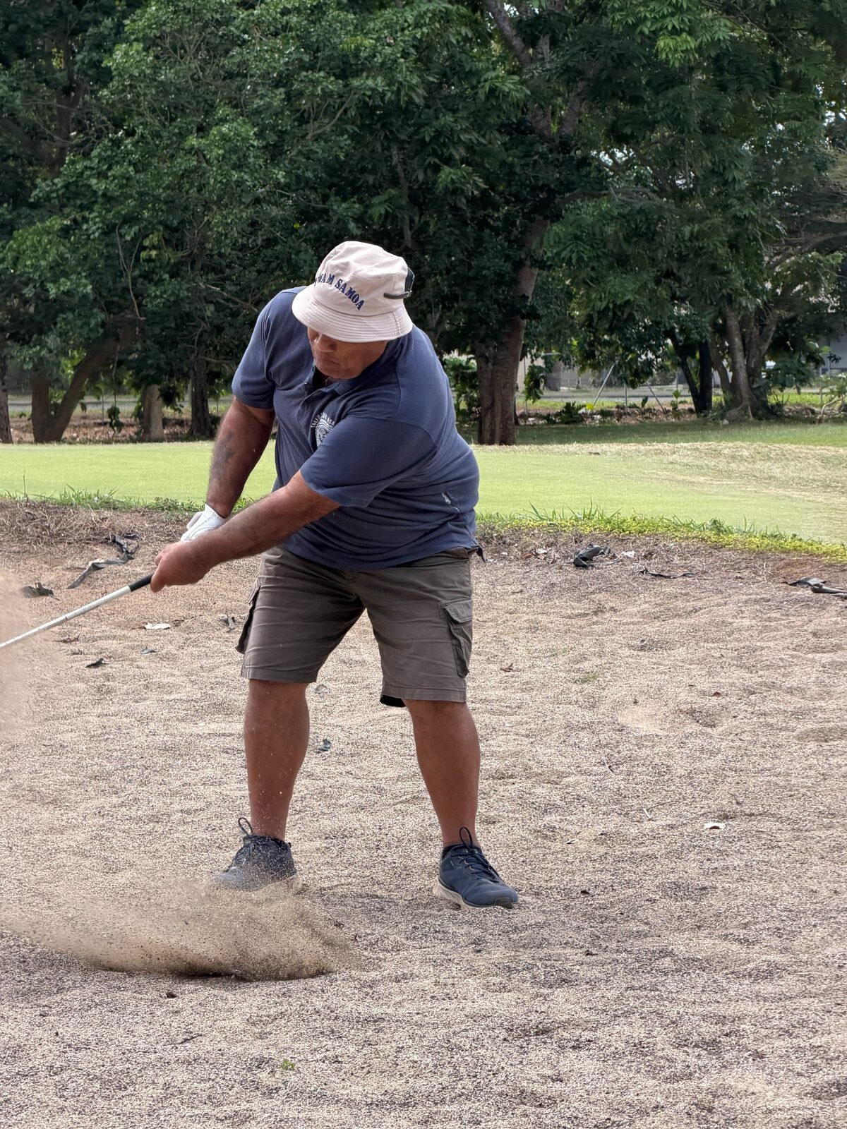 A golfer playing a shot from a bunker
