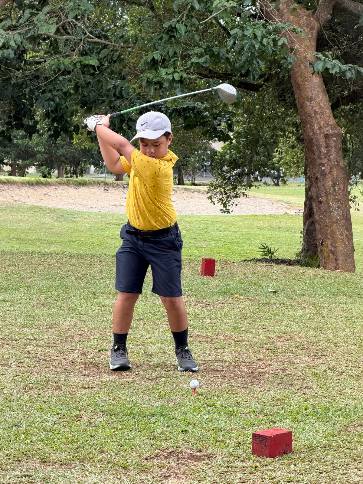 A junior golfer driving from the tee during the Samoa Open