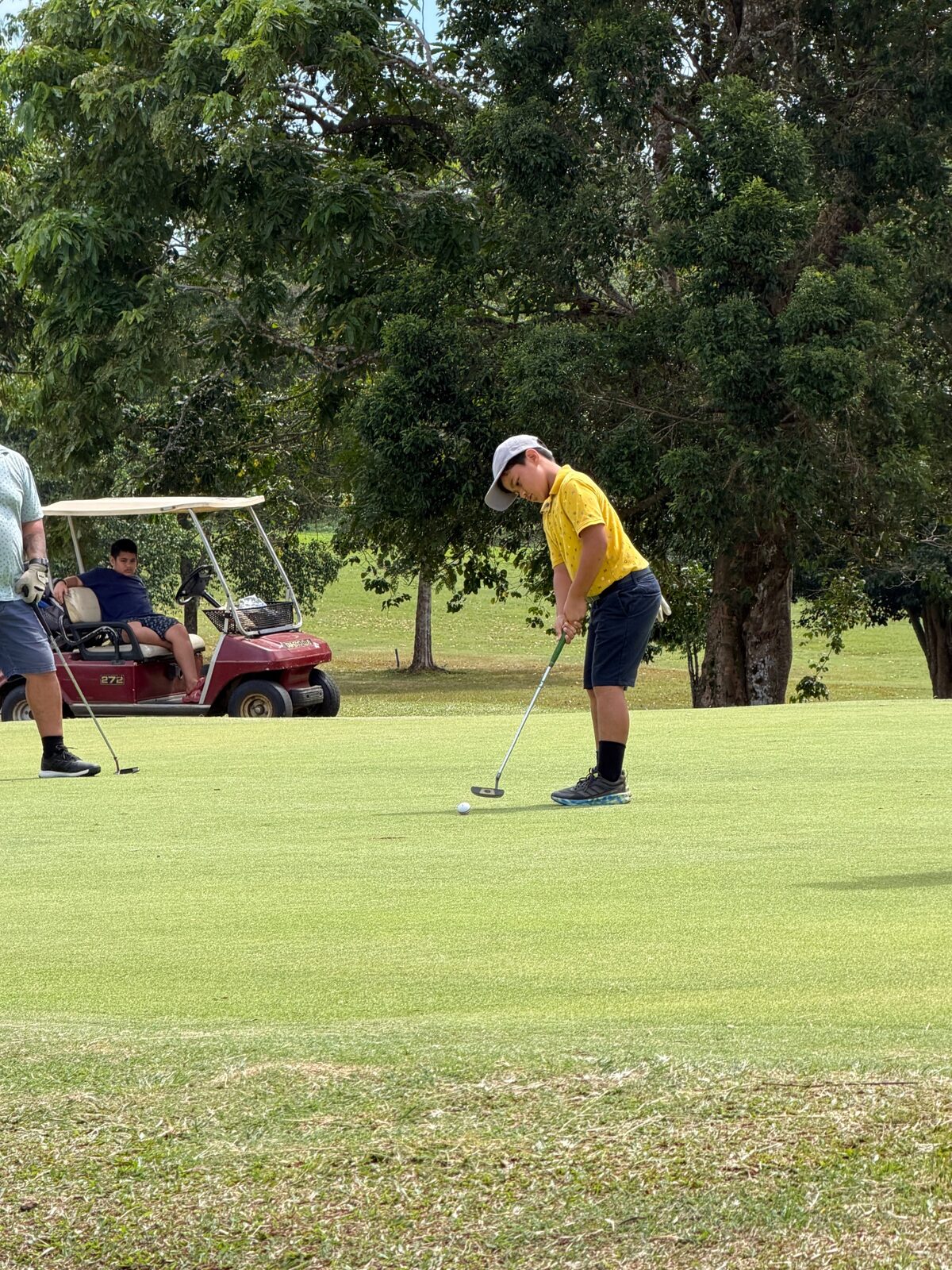 A junior golfer putting during the Samoa Open