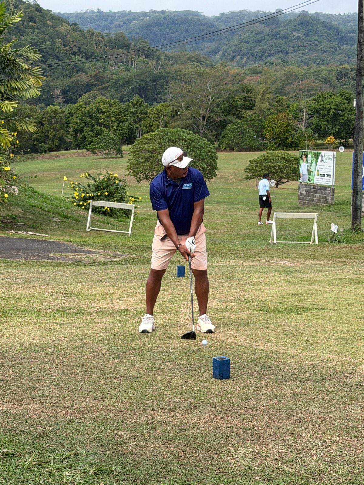 A woman golfer preparing to play from the tee