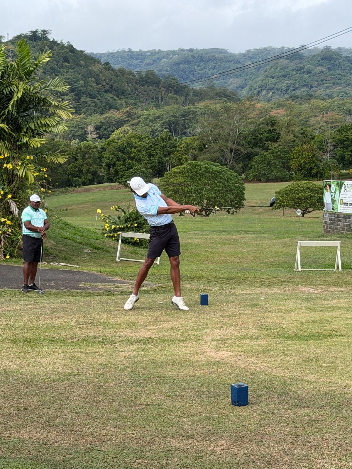 A woman golfer playing a full shot during competition